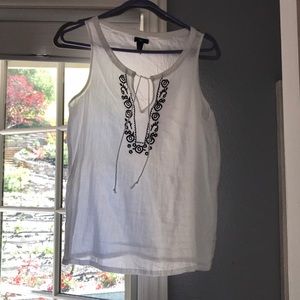 White tank. Black floral pattern around collar